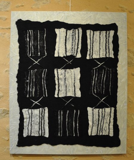 Les carrés sont en laine feutrée agrémentée de fils et fibres, installés sur un fond en tissus feutré, le tout cousu sur un châssis texturé