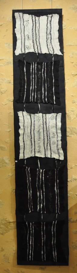 Les carrés sont en laine feutrée agrémentée de fils et fibres, le tout cousu sur un textile noir